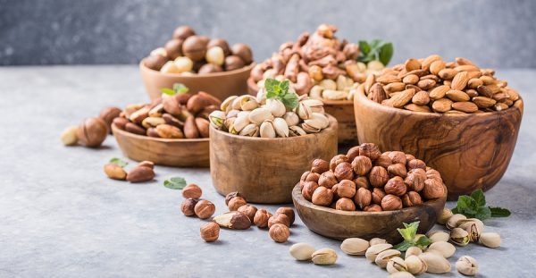 Assortment Of Nuts In A Wooden Bowls, On A Gray Background. Haze