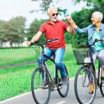 Portrait Of Happy Smiling Senior Couple On Bicycles Outdoors