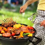 Man cooking meat on barbecue for family dinner